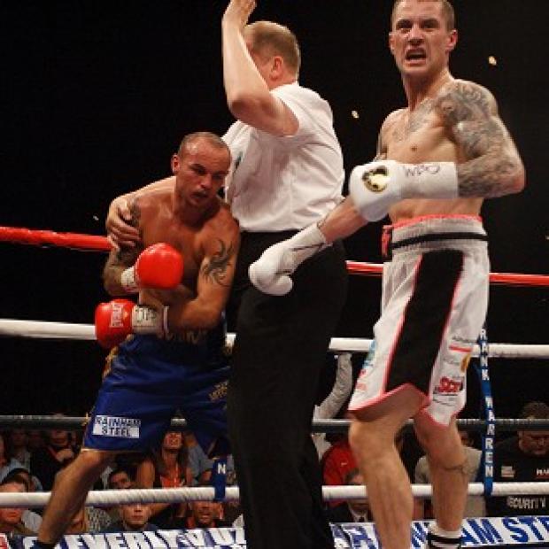 The referee stops the fight as victor Ricky Burns, right, wheels away in delight