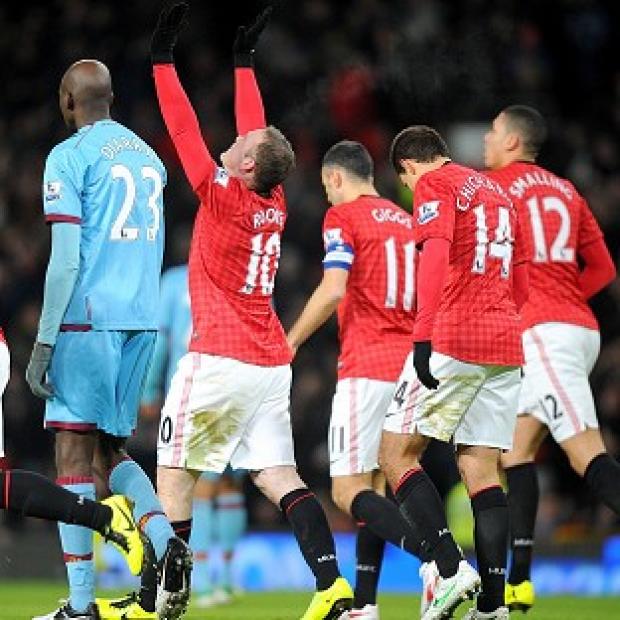 Wayne Rooney, centre, lifts his arms to the sky after scoring in the first half