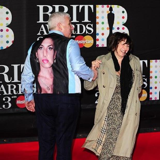 Mitch Winehouse arrives wearing a waistcoat bearing a picture of his daughter Amy