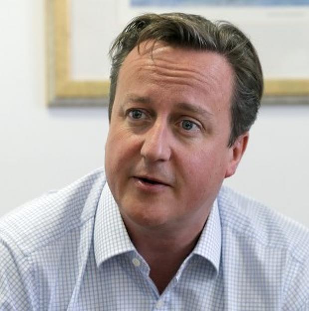 The budget crisis in the US reinforces the need for the Coalition's austerity measures, Prime Minister David Cameron has insisted