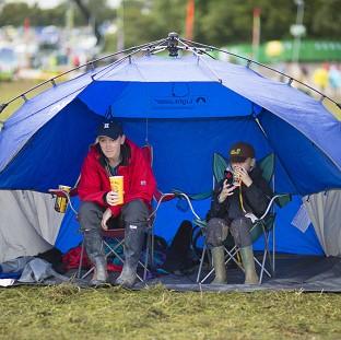 Congleton Guardian: Festivalgoers Christina Birch and Ben, aged 8, from St Albans prepare for more wet weather at the Glastonbury Festival Congleton Guardian: Festivalgoers Christina Birch and Ben, aged 8, from St Albans prepare for more wet weather at the Glastonbury Festival